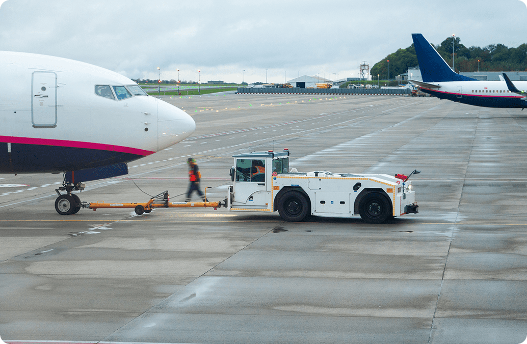 Airplane being towed by airport vehicle.