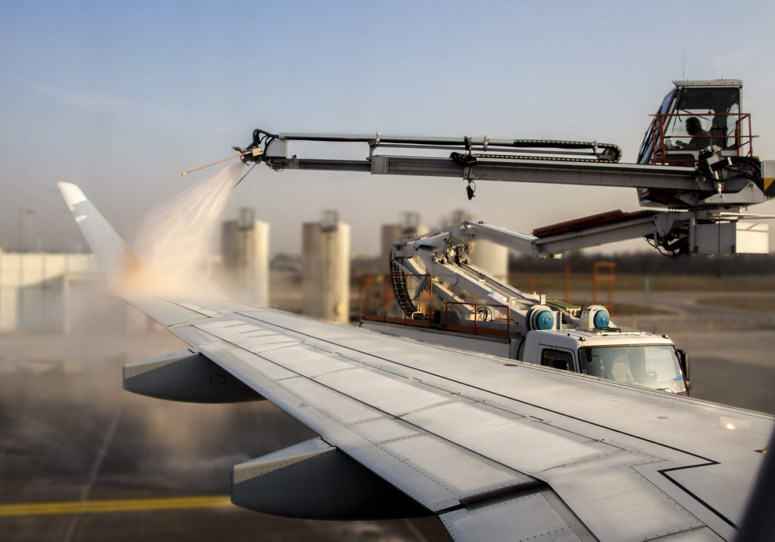 Airplane wing being de-iced at airport.